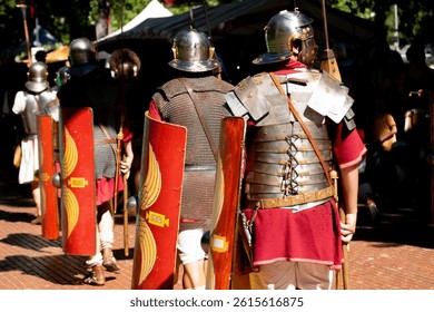 roman soldiers seen from behind with shields, roman army reenactment event