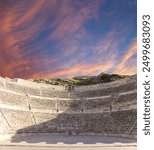 Roman Theatre in Amman, Jordan -- theatre was built the reign of Antonius Pius (138-161 CE), the large and steeply raked structure could seat about 6000 people. Against the sky with clouds 