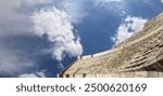 Roman Theatre in Amman, Jordan -- theatre was built the reign of Antonius Pius (138-161 CE), the large and steeply raked structure could seat about 6000 people. Against the sky with clouds 