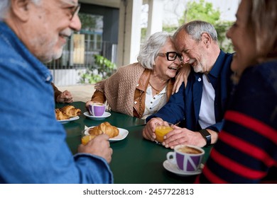 Romance in the elderly. Group of happy residents friends of a geriatric. Mature gray hair at coffee bakery cafe terrace at nursing home having fun breakfast. Caucasian senior citizens people together - Powered by Shutterstock