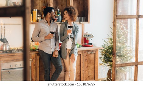 Romance in everyday life. Cheerful african-american man and woman enjoying wine at kitchen, panorama, copy space