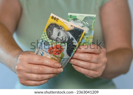 Romania money, Woman holds 200 lei and 1 lei banknotes in her hands, Financial concept