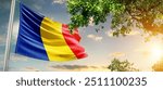 Romania national flag waving in the sky behind the tree. The flag blow in beautiful sunlight. Romania national flag for independence day.