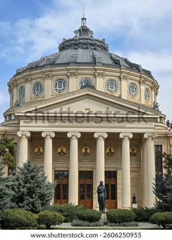 Romanian Athenaeum, Bucharest. Close-up of the neoclassical facade with its domed roof and grand columns. A statue stands in front, surrounded by greenery under a blue sky.