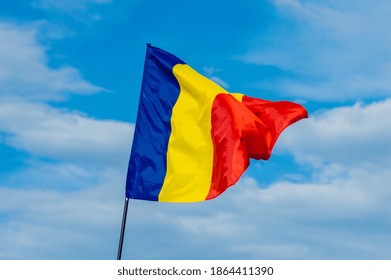 Romanian flag. December 1, Romania's National Day. Great Union Day. Romania flag waving on the blue sky with clouds