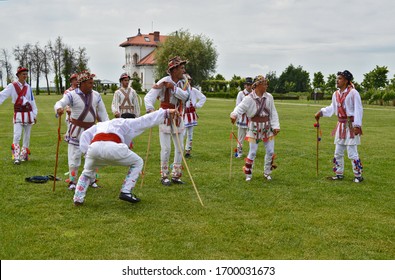 Romanian men dressed in traditional rustic clothing or "ie" performing dance called "Calus" or "Calusari", Old Romanian Traditions - Dragasani, Dolj / Romania - 5/28/2018