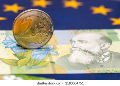 Romanian Money Next To A 2 Euro Coin, Concept Of Romania Joining The Single Currency Of The European Union