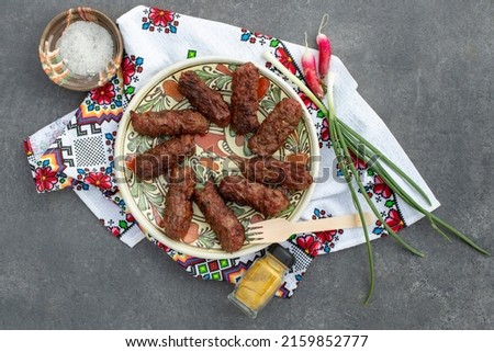 Romanian , traditional meat rolls, called ”mici” or ”mititei”     on a   ceramic plate, grilled minced meat 