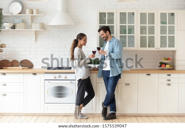 Romantic affectionate beautiful young couple holding glasses stand