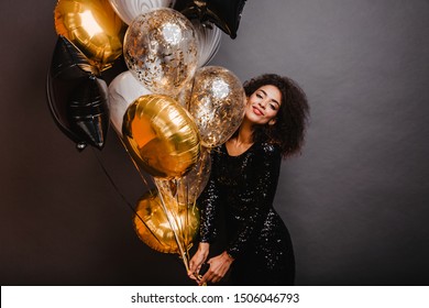 Romantic African Girl Holding Bunch Of Party Balloons. Indoor Shot Of Graceful Black Lady Celebrating Birthday.