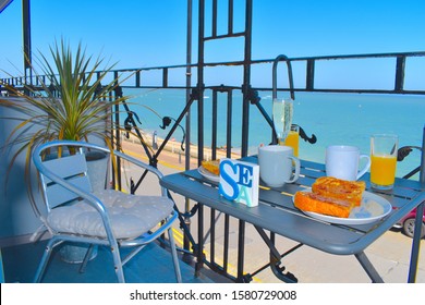 Romantic al fresco breakfast at the Kentish seaside - tea, coffee, orange juice and toast served at the sunny balcony overlooking the sea. Herne Bay central beach, Kent, UK - Powered by Shutterstock