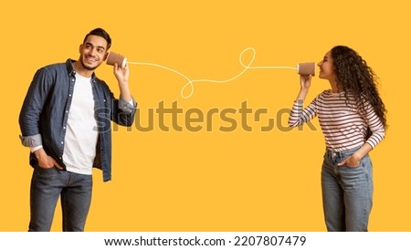 Romantic Arab Couple Communicating Through Tin Phone Over Yellow Background, Beautiful Middle Eastern Woman Sending Love Message Via Drawn String To Her Excited Boyfriend, Collage, Copy Space