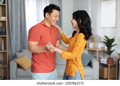 Romantic Asian Spouses Dancing At Home, Loving Korean Middle Aged Man And Pretty Young Woman Having Good Time Together, Side View. Romance In Relationships, Marriage Concept