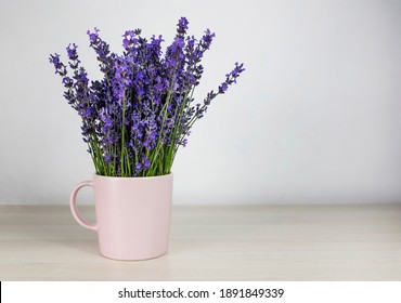 Romantic background. Fresh natural lavender in a pink cup against a white wall background. Side view, space for text. - Powered by Shutterstock