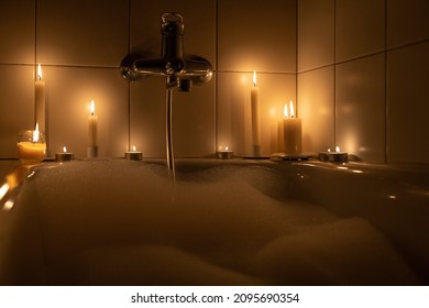 Romantic Bathroom With White Foam By Candlelight In The Dark