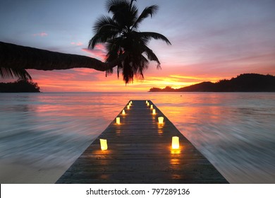 romantic beach with wooden jetty and lamps, romantic travel