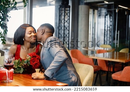 Romantic black couple sitting at restaurant wearing elegant clothes