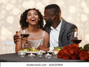 Romantic black man courting his pretty girlfriend while having valentine dinner in restaurant - Powered by Shutterstock