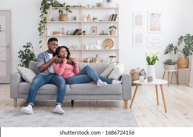 Romantic black spending time at home together, relaxing on sofa and cuddling, copy space - Powered by Shutterstock