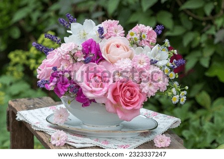romantic bouquet of pink roses, sweet peas, lavender and jasmine flowers in vintage sauce boat