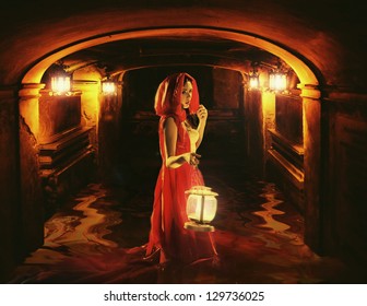 Romantic Brunette Holding A Lantern In A Dark Dungeon