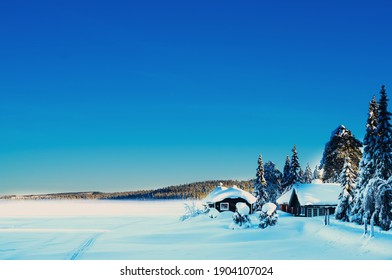 Romantic cabin by a frozen remote lake covered with snow on a bright sunny winters day. - Powered by Shutterstock