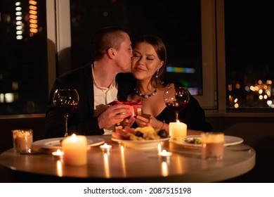 Romantic Candlelight Dinner For Two, Valentine's Day Date, Authentic Couple Having Dinner With A Man Giving A Gift To A Woman, Romantic Family Relationship, Valentine's Day Celebration Concept