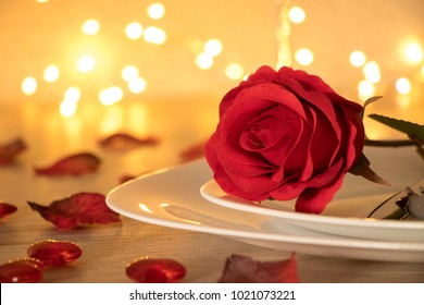 
Romantic Candlelite Table Setting with a red rose on a wooden table
