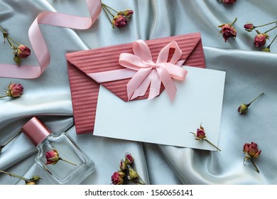 romantic composition. perfume bottle, envelope and jewelry. top view. flat lay