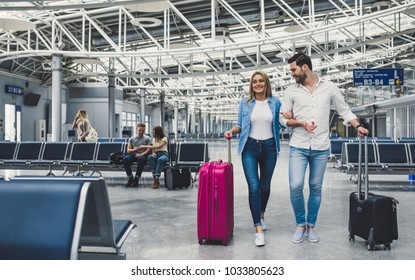 Romantic Couple In Airport. Attractive Young Woman And Handsome Man With Suitcases Are Ready For Traveling.