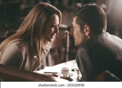 Romantic couple at the bar staring at each other's eyes - Shutterstock ID 255520930