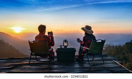 Romantic couple camping outdoors and taking photos with camera while camping at sunrise. Doi Luang Chiang Dao mountains in Chiang Mai. - Powered by Shutterstock