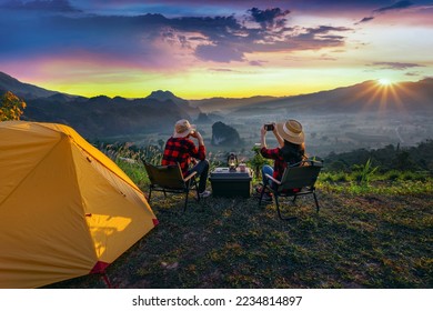 Romantic couple camping outdoors and taking photos with camera while camping at sunrise. Phu Lang Ka, Pha yao province in Thailand. - Powered by Shutterstock