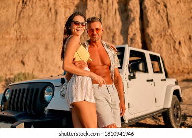 Romantic couple with car parked on the beach. Summer vibes. Traveling together to the sea. Safari on SUV vehicle. - Powered by Shutterstock