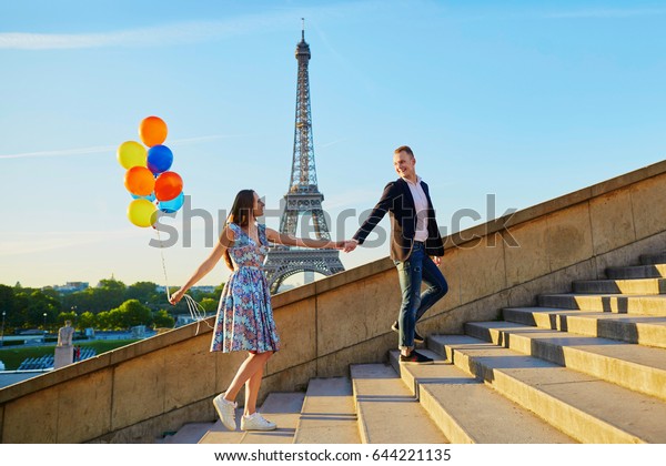 フランス パリのエッフェル塔の近くに色とりどりの風船を持つロマンチックな夫婦が階段を上がる の写真素材 今すぐ編集