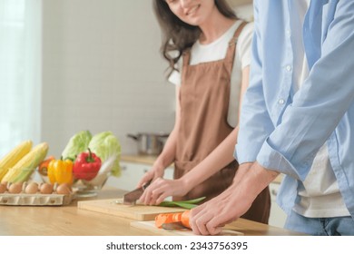 Romantic couple is cooking Handsome man and charming young woman are having while making salad, healthy lifestyle concept. Man girl standing in kitchen at home Spouses enjoy warm cooking process  - Powered by Shutterstock