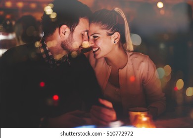 Romantic couple dating in pub at night - Shutterstock ID 510772972