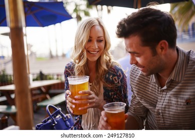 Romantic Couple Drinking Beer At Outdoor Restaurant