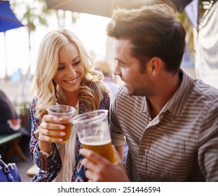 Romantic Couple Drinking Beer In Plastic Cups At Outdoor Bar