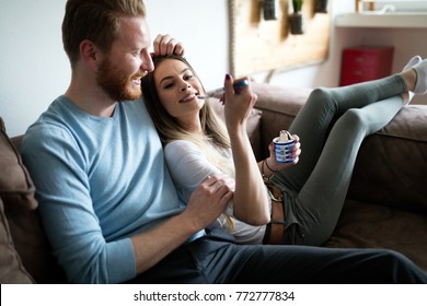 Romantic couple eating ice cream together and watching tv