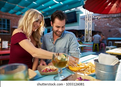 Romantic Couple Eating Tacos And Nachos At Mexican Restaurant