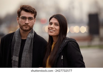 A romantic couple embraces in a tender hug as they stroll through the city streets, enjoying leisure time together in each other's company - Powered by Shutterstock