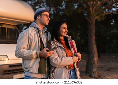 Romantic Couple Embracing Each Other While Standing At The Nature. Warm Clothes On, Autumn Time. In Background Forest And Car