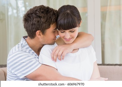 Romantic couple embracing on sofa in living room