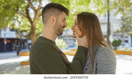 Romantic couple embracing outdoors in an urban park setting with affectionate gaze, showcasing love and relationship. - Powered by Shutterstock