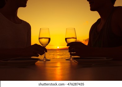 Romantic couple enjoying a glass of wine and a beautiful sunset. 