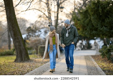 Romantic couple enjoying a walk in the park holding hands - Powered by Shutterstock