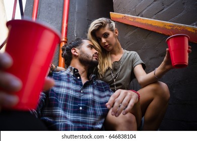 Romantic couple enjoying while having drink on staircase of bar - Powered by Shutterstock