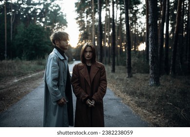 romantic couple in the forest in a coat, gloomy date sadness and peace.