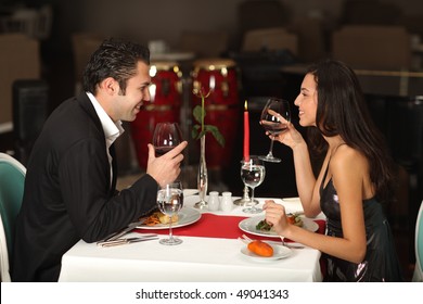 Romantic couple having dinner, smiling to each other